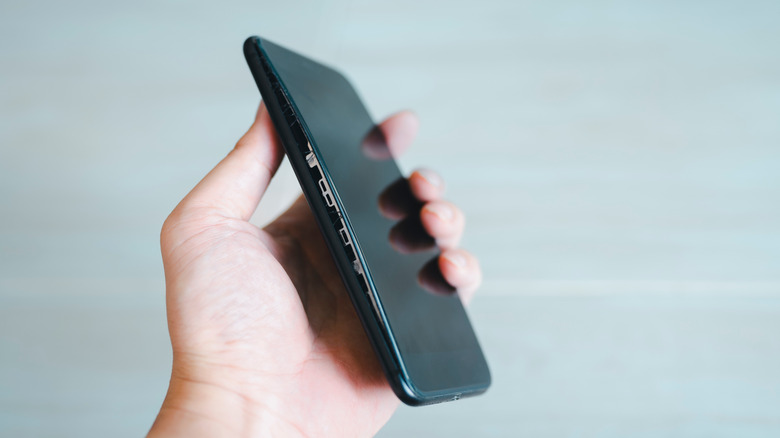 A swollen phone with the screen bent and disconnecting from the back chassis