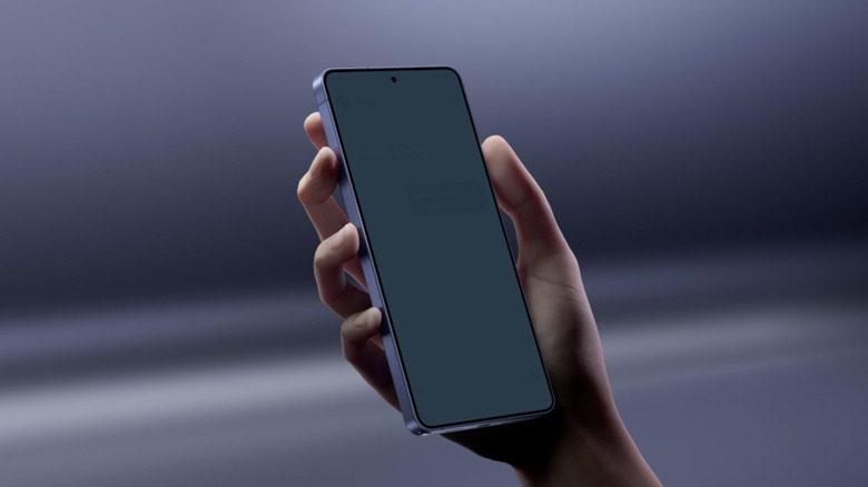 A close up of a 3D-rendered hand holding a Samsung Galaxy S26 Ultra in front of an abstract background.