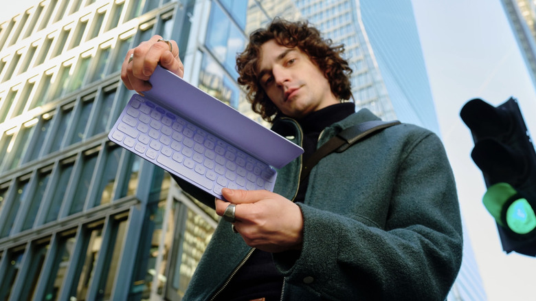 A person holding the Logitech Keys-To-Go-2 keyboard.