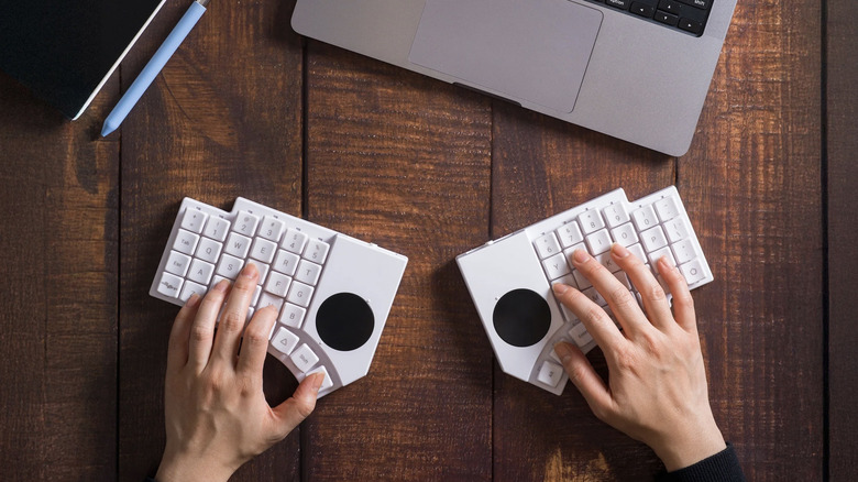 A person typing on the MoErgo Go60 keyboard.
