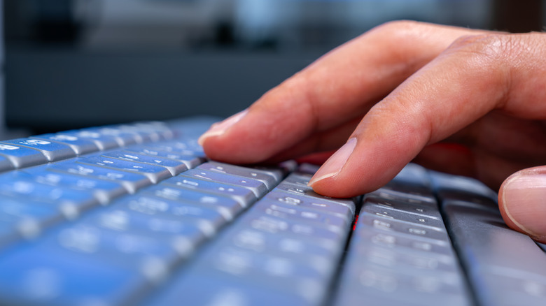 Closeup view of a person typing on a keyboard