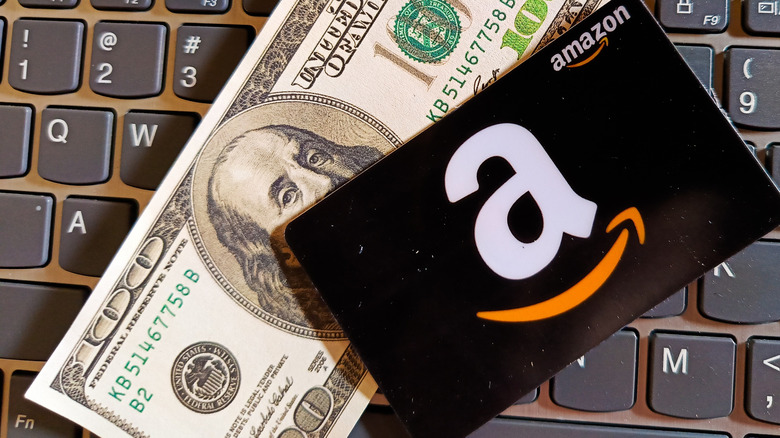 An Amazon gift card and laid on top of a bank note