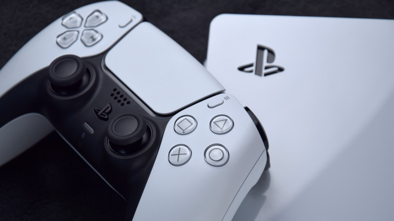 DualSense controller on top of a PS5 console on a white background