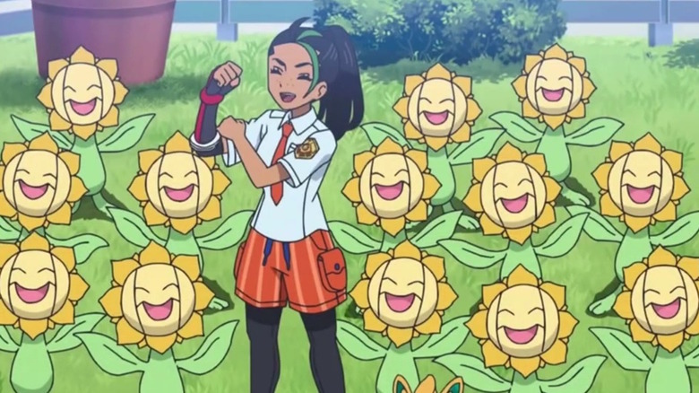 a trainer in violet and scarlet with several sunflora around her