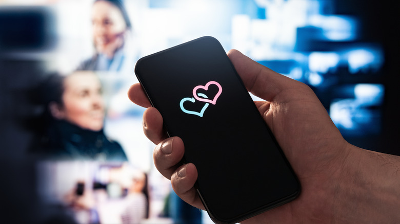 hand holding a phone screen with two hearts on it