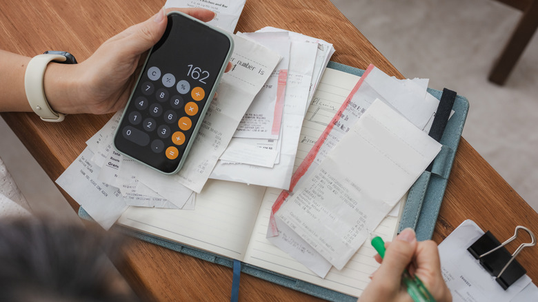 person working with a pile of bills and receipts