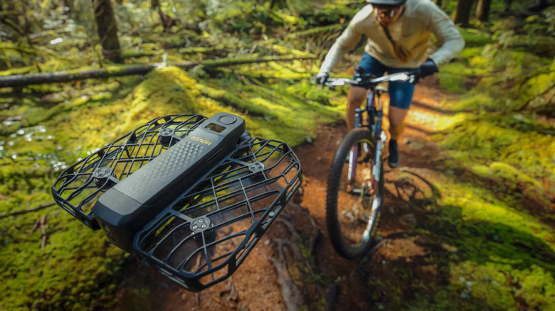 HoverAir X1 PROMAX promo image showing it filming its owner cycling
