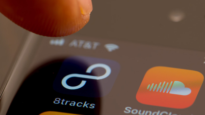Someone tapping the 8Tracks app on a phone.