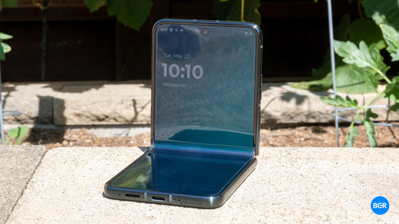 Motorola Razr Ultra (2025) close up sitting on sidewalk, folded open.