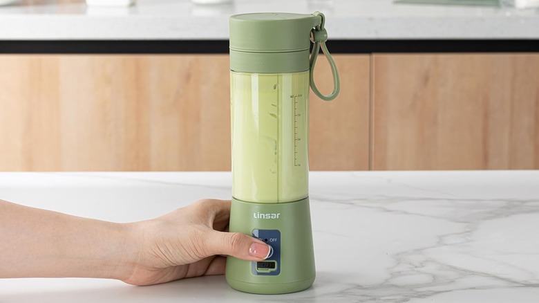 A portable USB blender mixing a green drink