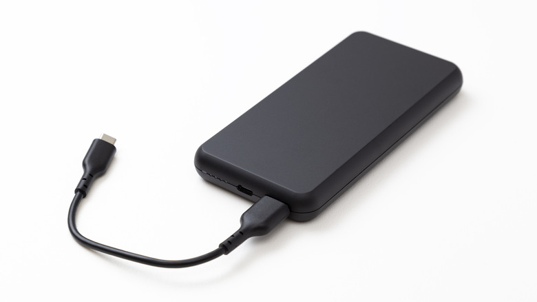 A black power bank with a cable attached
