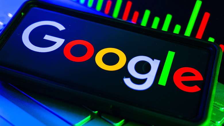 Google logo on a smartphone lying on a Chromebook keyboard