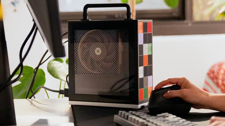 Framework Desktop on a desk with a handle attached on top