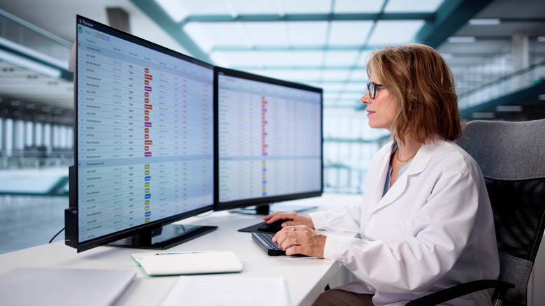 An office worker using productivity software across two screens