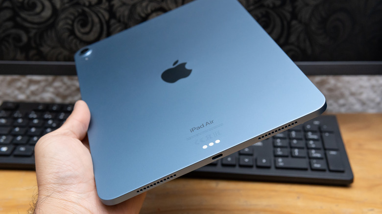 A blue iPad Air with a keyboard in the background