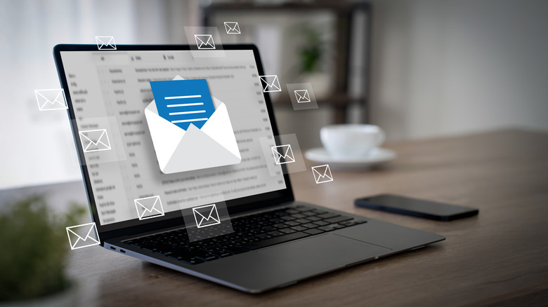 A laptop displaying a several floating email icons in front of screen