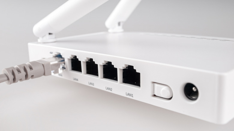 An Ethernet cable plugged into a white internet router.