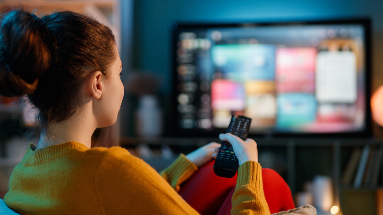 Person browsing apps on a smart TV at home.