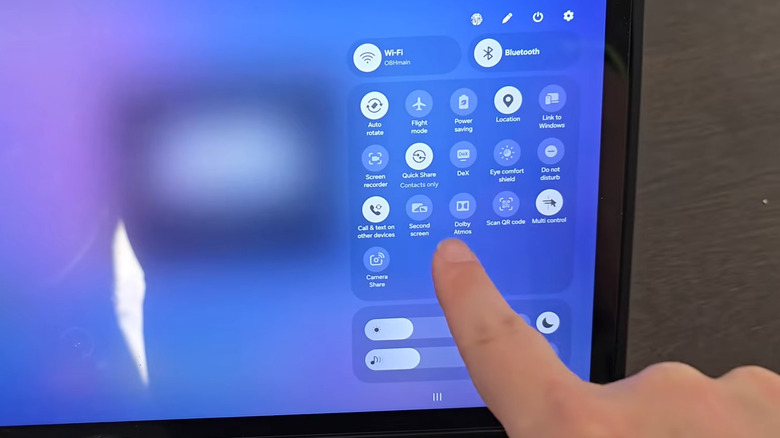 A hand pointing to Second screen in the Quick Settings on a Samsung Galaxy tablet
