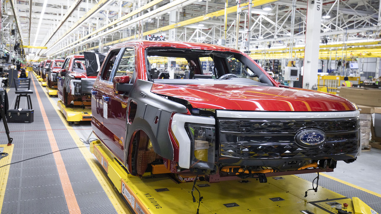 Several unfinished trucks sit in the Ford F-150 Lightning production line.