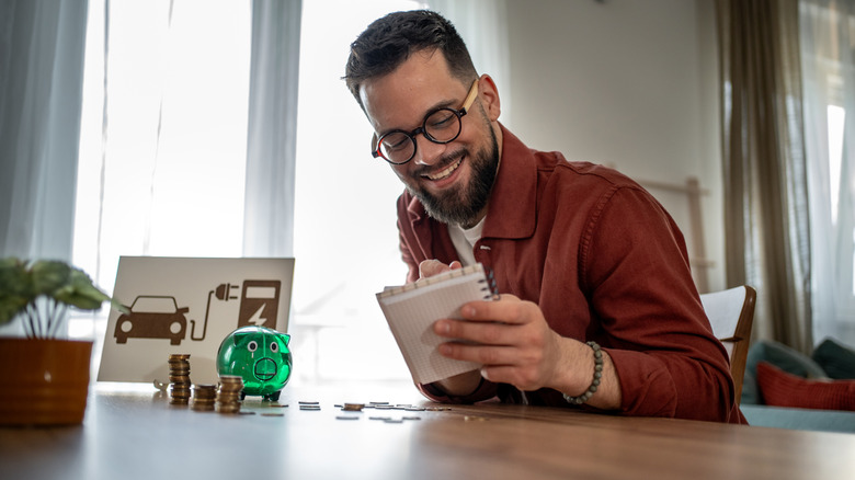 A man plans out his finances for an upcoming EV purchase.