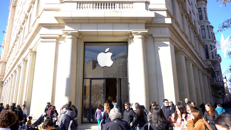 People standing in front of the entrance of an Apple retail store