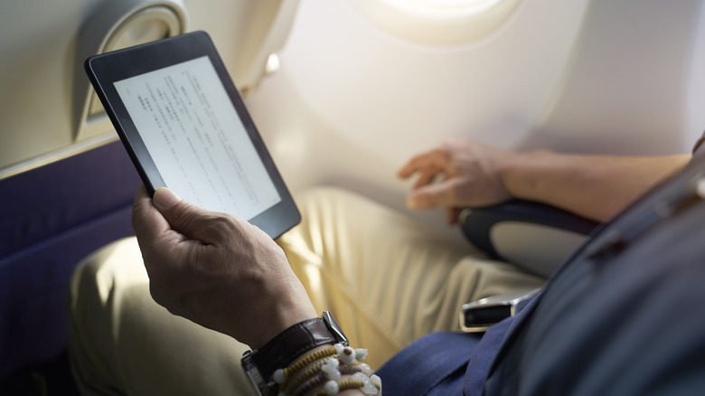 Person reading an ebook on Kindle inside an airplane