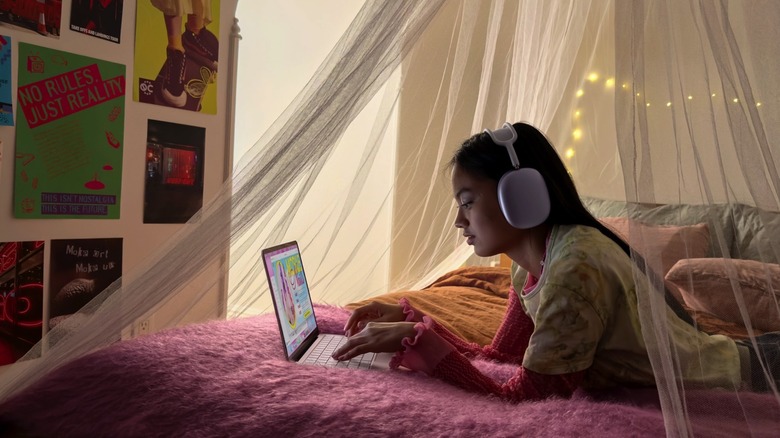 A teenager using a MacBook Neo laptop.