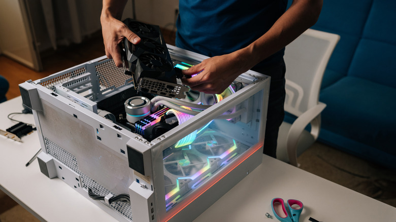 Person installing a graphics card into a desktop PC case
