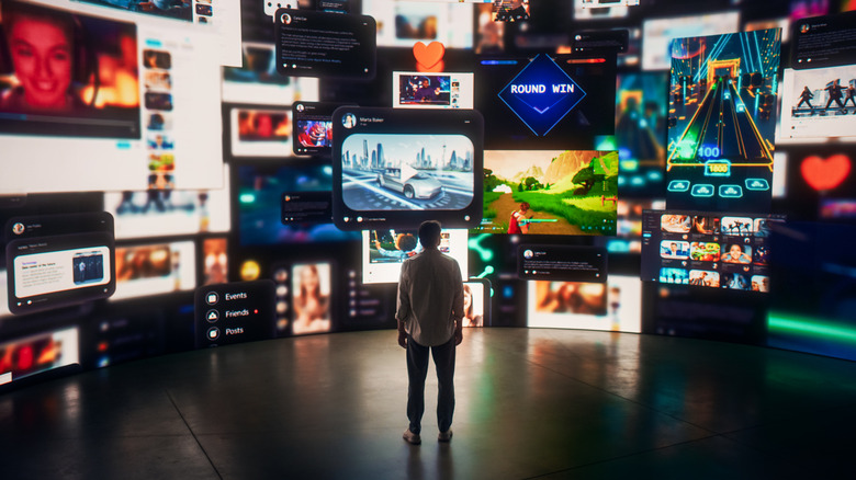 A person stands surrounded by screens with ads on them