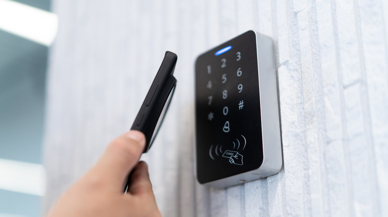 Close-Up of a touchpad smart lock with someone using their phone nearby