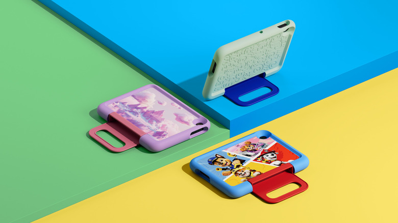 Four of Amazon's new Kids tablets on colored backgrounds showing character cases and kickstands