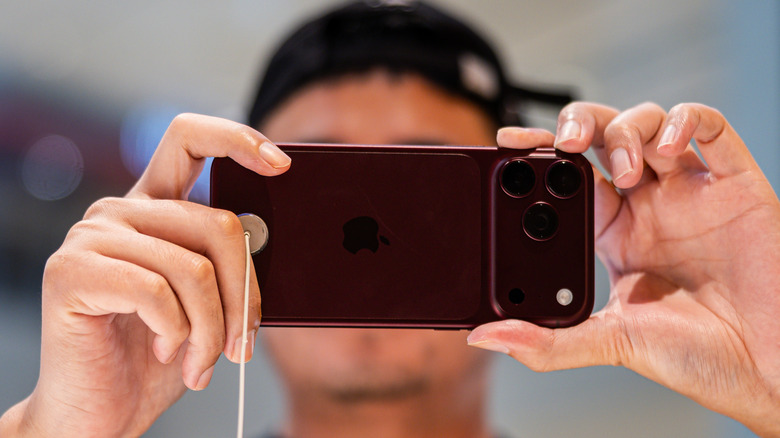 A person testing the iPhone 18 Pro Max camera in a store.