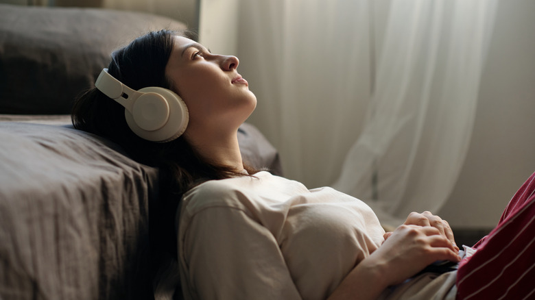 A woman relaxes with a set of wireless headphones