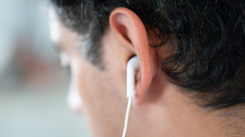 Close-up of an earbud in a man's ear