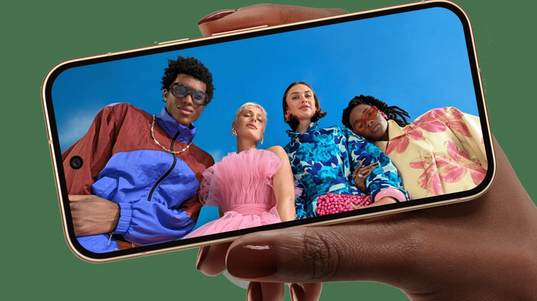 Pixel 11 held in hand showing screen with people on it as if taking a photo