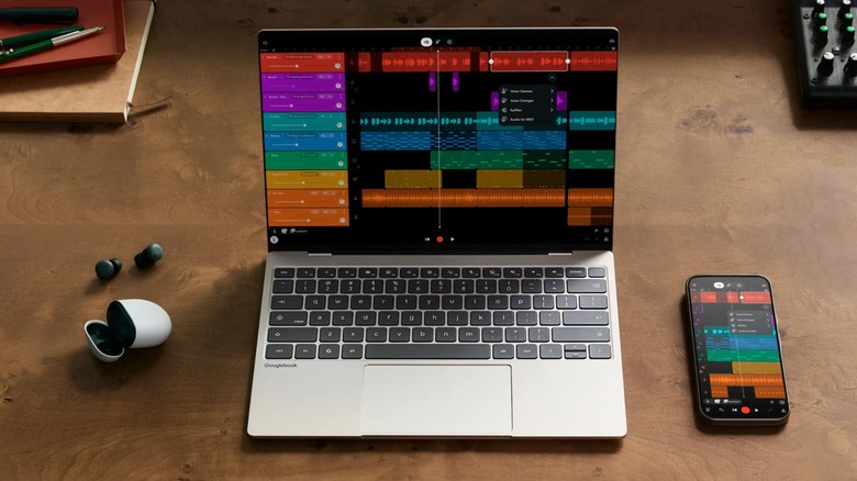 A silver Googlebook displaying a digital audio workstation (DAW) as an Android smartphone displays the same information, a pair of Google earbuds sit out their carrying case next to the laptop