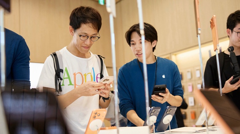 Apple retail consultant helping a customer with the new iPhone