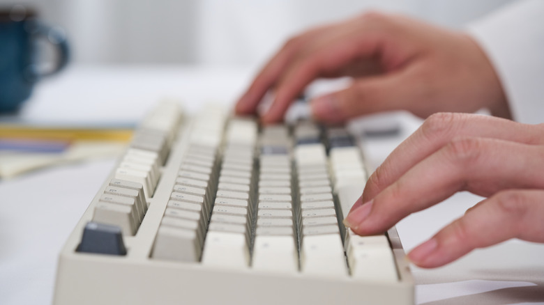 Close-up of hands typing on a mechanical keyboard
