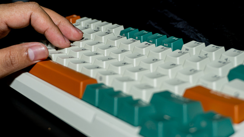 A hand resting on a mechanical keyboard