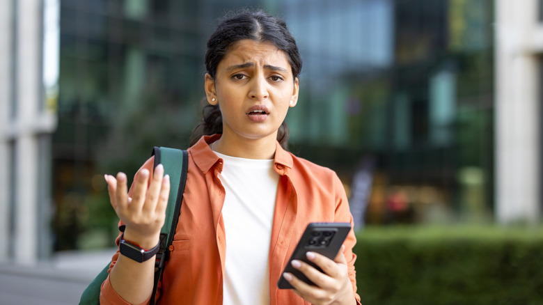 Frustrated woman holding a phone