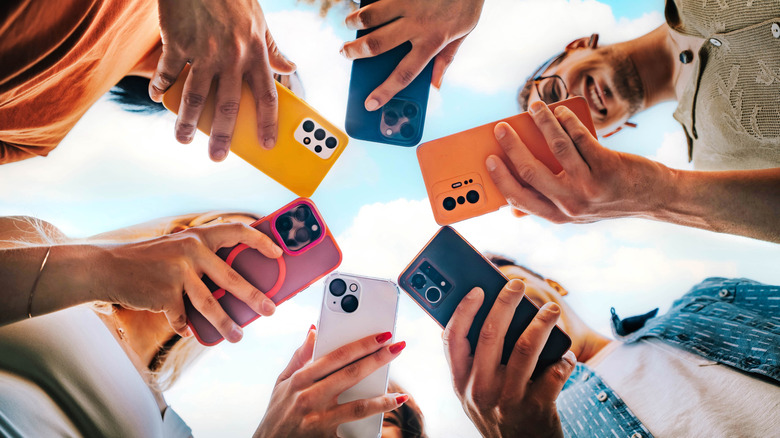 Group of people using smartphones outside