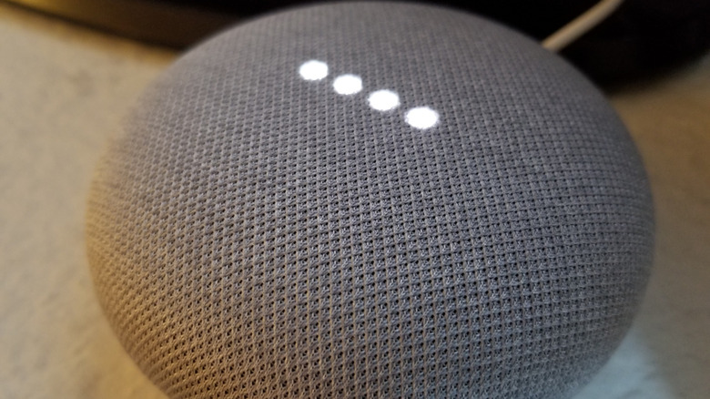 A close up of a Google Home Mini on a marble worktop.