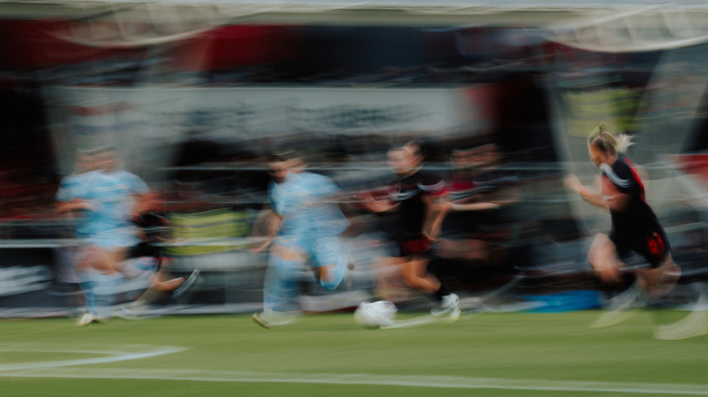 A blurred football game image representing ghosting on a MINI-LED monitor