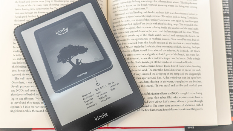 An Amazon Kindle on top of an open book