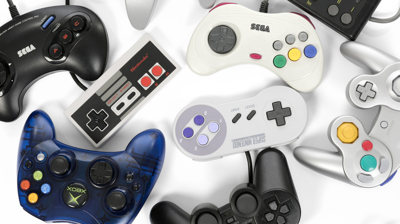 A collection of retro gaming controllers on a white background