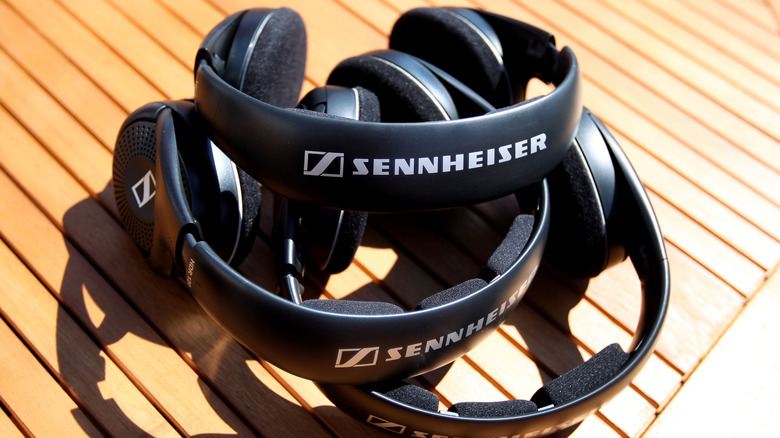 Sennheiser Momentum 4 Wireless on a distorted Sennheiser logo background.