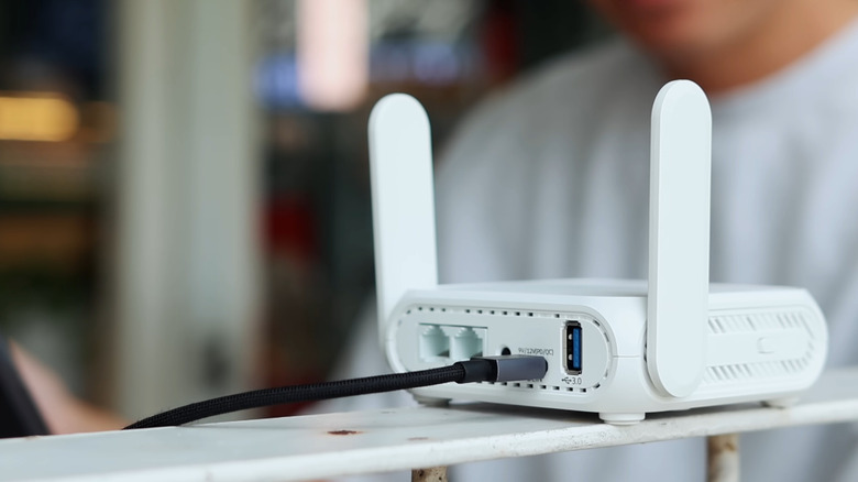 back side of an ASUS travel router with the LAN, power, and USB port visible