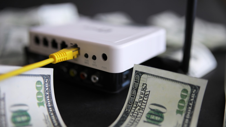 white router placed next to a 100 dollar bill