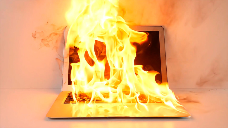 A silver laptop on fire